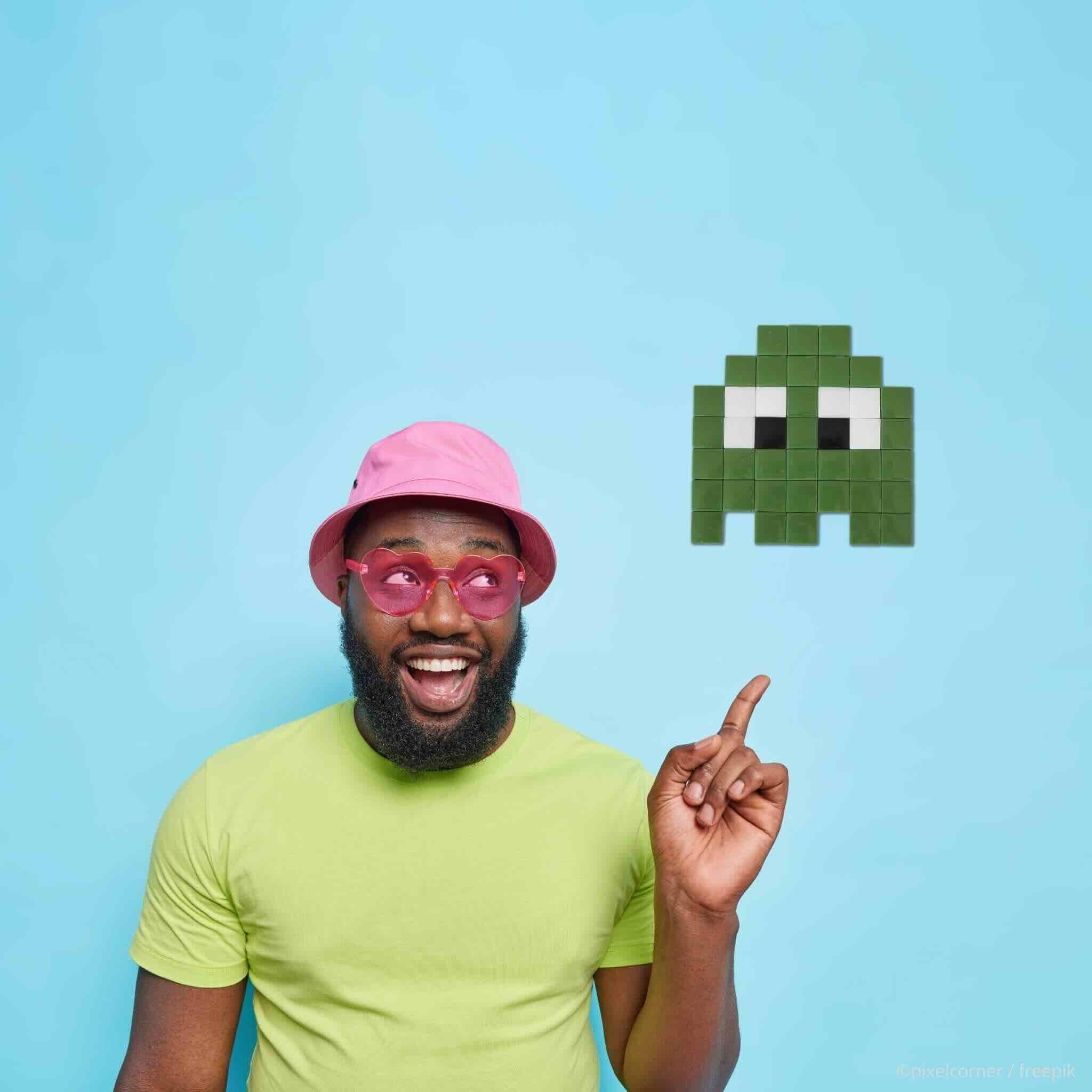 Pixel Art Kit "Les Gloomie(s)" - Kits de loisirs créatifs, un homme noir t-shirt vert et lunette rose heureux montre un fantome vert pixel art en mosaique diy