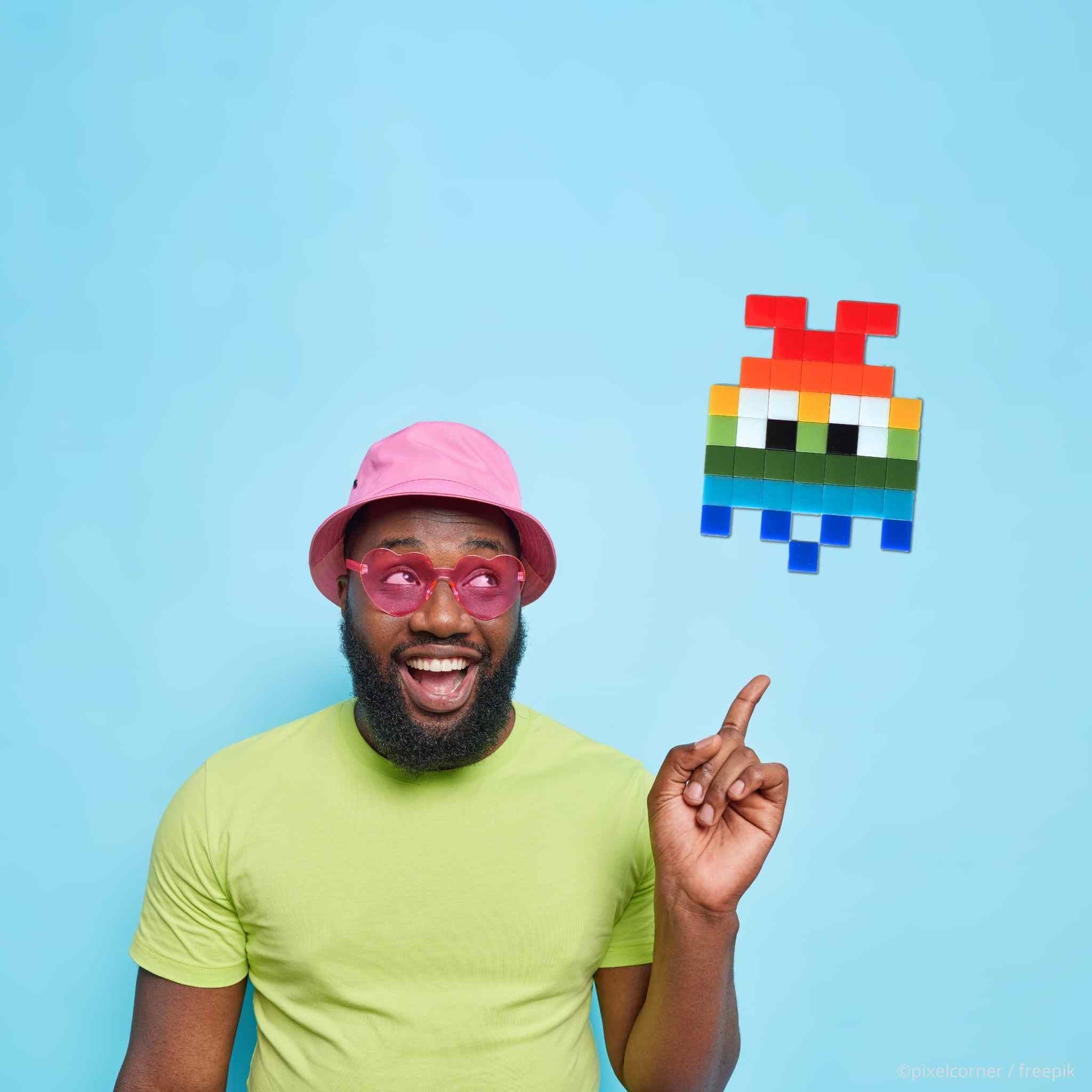 un homme noir sur fond bleu et lunette rose lgbt montrant le Pixel Art Kit diy "Rainbow Gloom" par Pixel Corner - Kits de loisirs créatifs