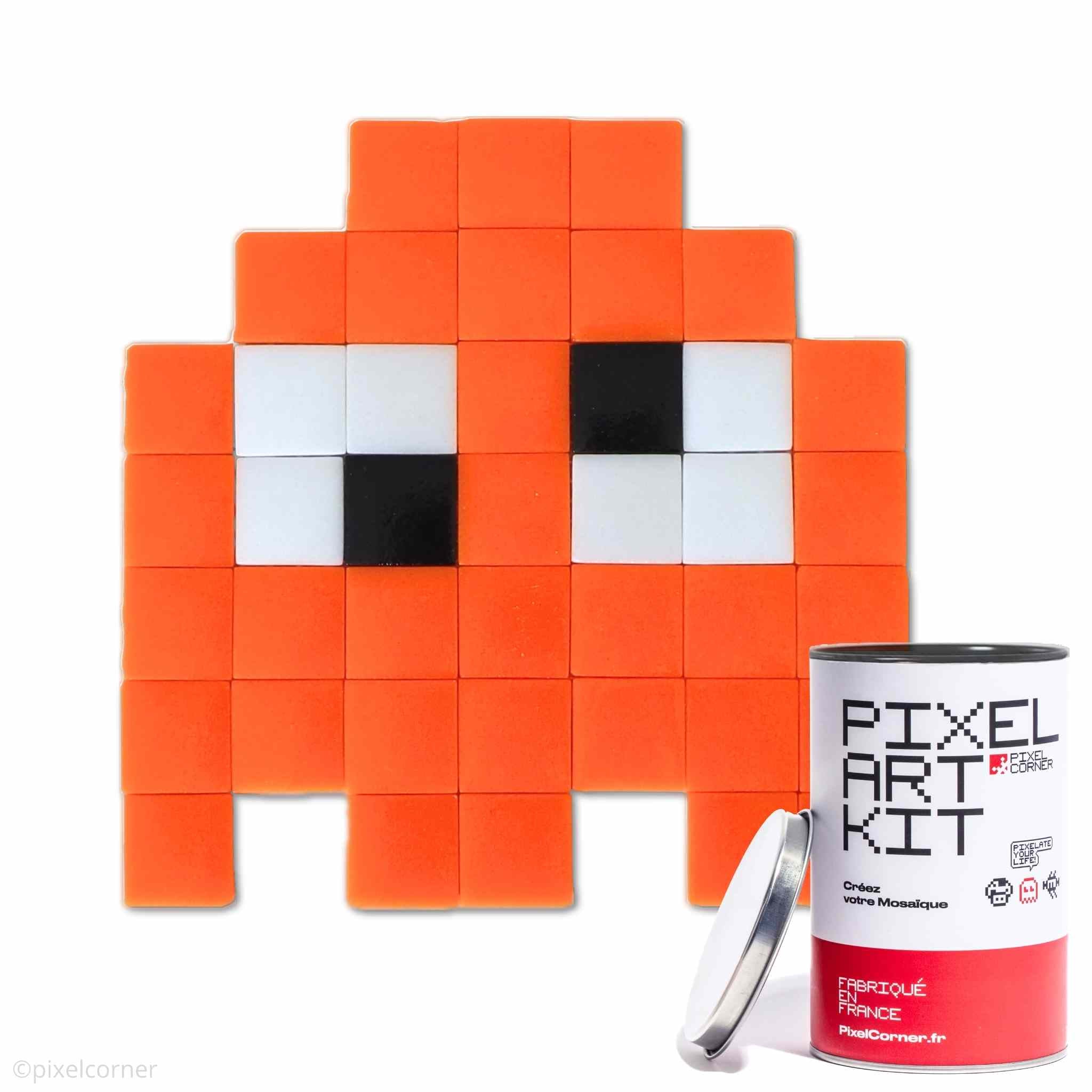 Un fantome orange et yeux rigolo en pixel art avec des carreaux de mosaïque de verre avec une boite de pixel art kit au premier plan