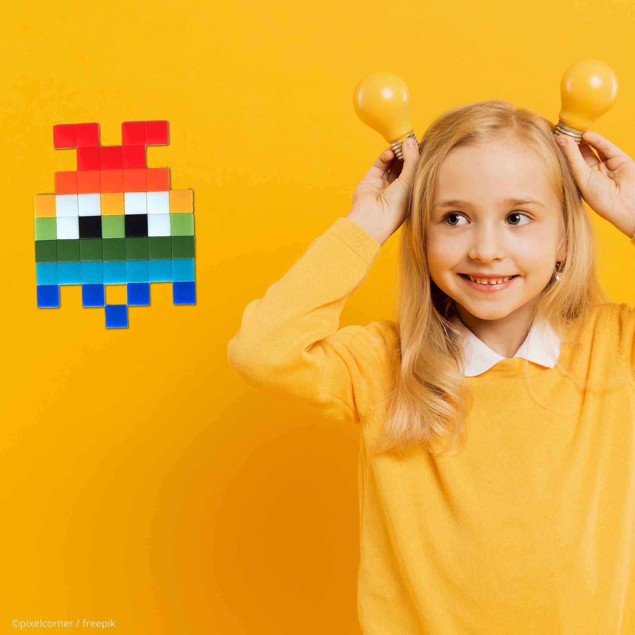 une petite fille sur fond jaune qui fait des antennes avec ses mains en regardant un alien invader fantome pacman en pixel art diy mosaïque de verre